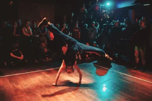 A person dancing on a dancefloor and other observing